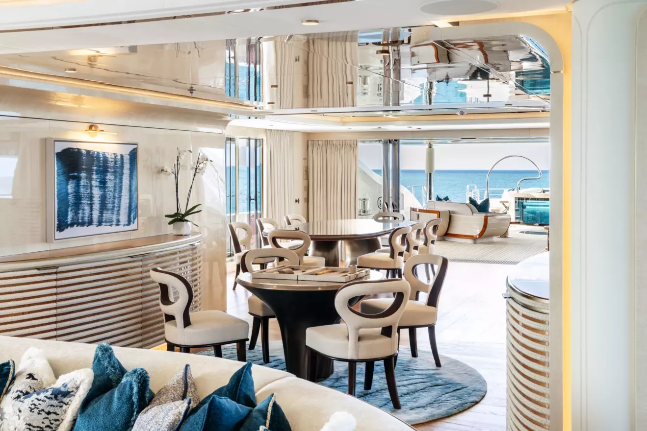 Sophisticated interior of the main lounge on Amor &agrave; Vida with floor-to-ceiling windows, polished sycamore ceilings, and Java teak flooring