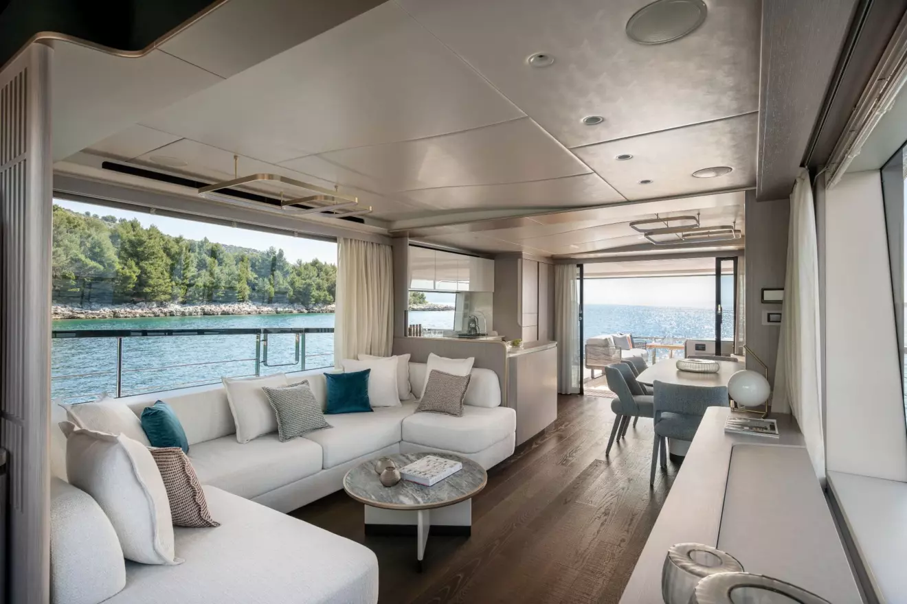 Bright main salon of the Absolute 70 Fly with large windows, light wood furniture, and modern design